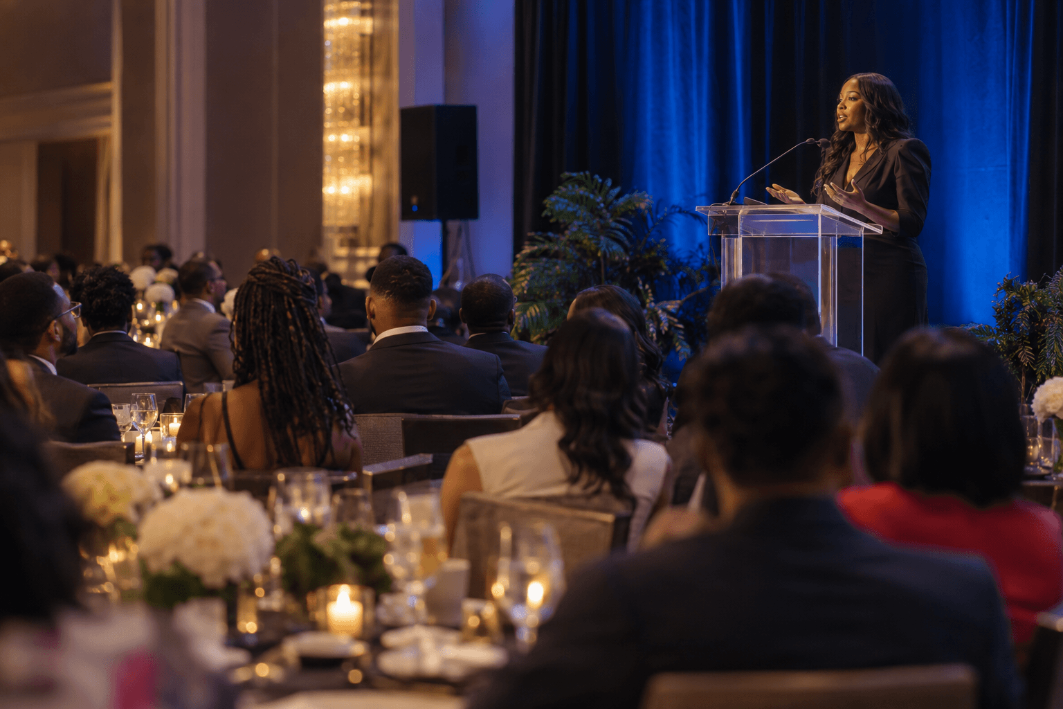 A speaker making an announcement to an audience of young professionals
